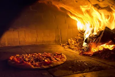a pizza is cooking in a brick oven at Villa Garden in Banja Luka