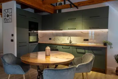 a kitchen with a wooden table and blue chairs at Apartman Rustic Charm in Livno