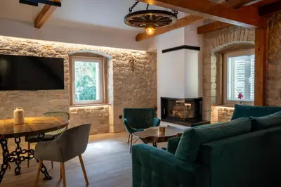 a living room with a couch and a table and a tv at Apartman Rustic Charm in Livno
