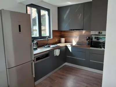 a kitchen with gray cabinets and a white refrigerator at Divanhana na Uni in Bosanska Krupa