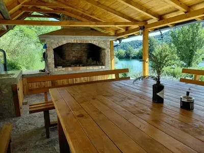 a wooden deck with a fireplace and a bench at Divanhana na Uni in Bosanska Krupa