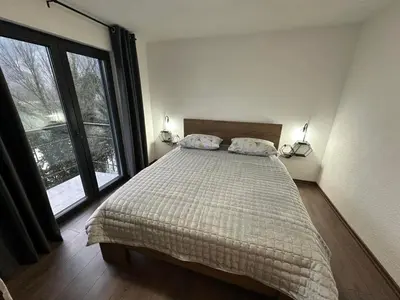 a bedroom with a bed and a large window at Divanhana na Uni in Bosanska Krupa