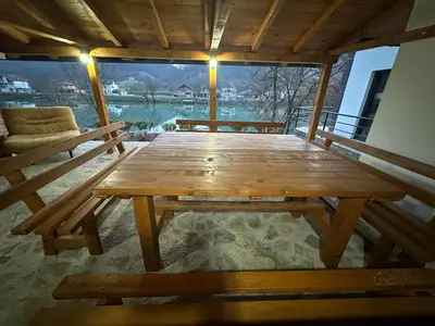 a wooden table and a chair on a porch at Divanhana na Uni in Bosanska Krupa