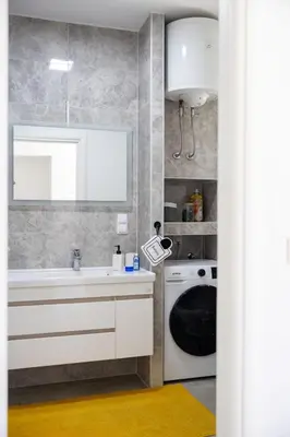 a bathroom with a sink and a washing machine at Una Riverside Heritage House in Bihać