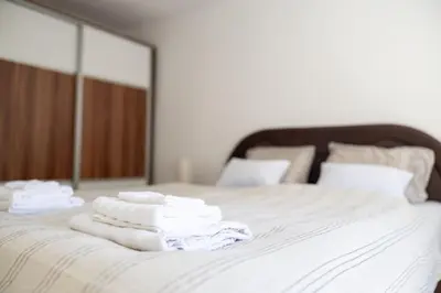 a pile of towels on a bed with a mirror at Una Riverside Heritage House in Bihać