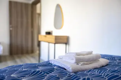 a pile of towels sitting on top of a bed at Una Riverside Heritage House in Bihać
