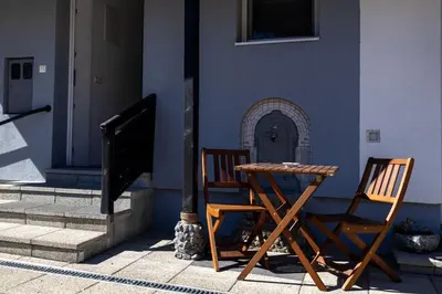 two chairs and a table in front of a building at Una Riverside Heritage House in Bihać