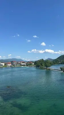 a large body of water with trees and buildings at Una Riverside Heritage House in Bihać