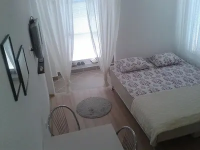 a small bedroom with a bed and a window at Apartment Elma in Visoko