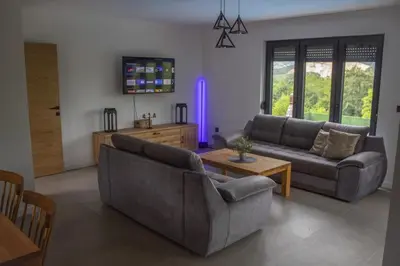 a living room with two couches and a table at Vikend kuća Ljetni San in Gračanica