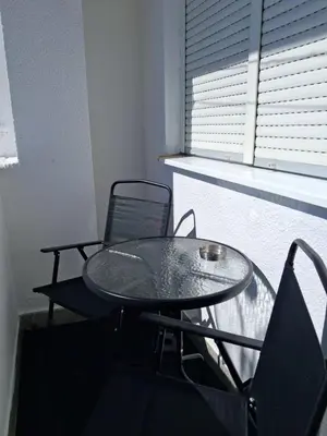 a table and chairs in a room with a window at Na korak do Vrbasa - blizu centra in Banja Luka