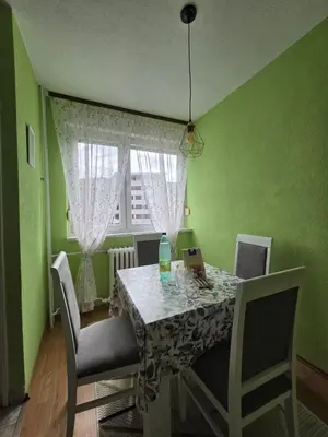 a dining room with a table with chairs and a window at Na korak do Vrbasa - blizu centra in Banja Luka
