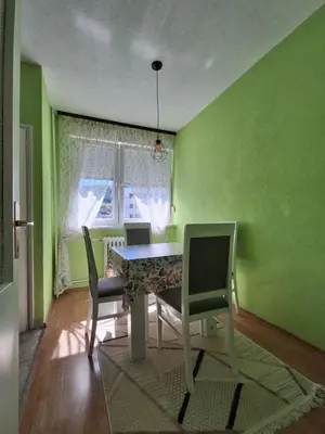 a dining room with green walls and a table and chairs at Na korak do Vrbasa - blizu centra in Banja Luka