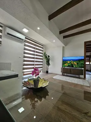 a living room with a table and a large painting on the wall at Visoko Luxury Residence in Biskupići
