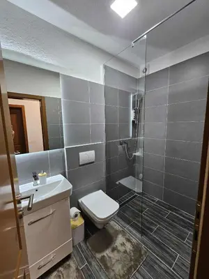 a bathroom with a toilet and a glass shower at Visoko Luxury Residence in Biskupići