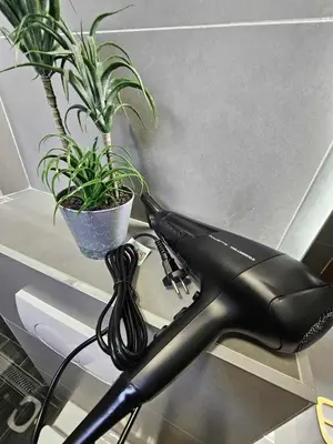 a black hair dryer sitting on a table next to a plant at Visoko Luxury Residence in Biskupići