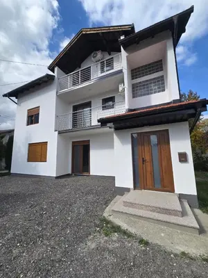 a white house with brown doors and a driveway at Visoko Luxury Residence in Biskupići