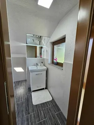 a small bathroom with a sink and a mirror at Visoko Luxury Residence in Biskupići