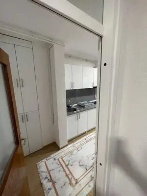 an open door to a kitchen with white cabinets at Visoko Centar Apartment in Visoko
