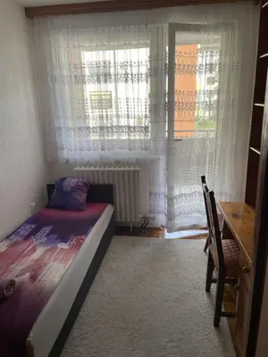 a bedroom with a bed and a desk and a window at Visoko Centar Apartment in Visoko