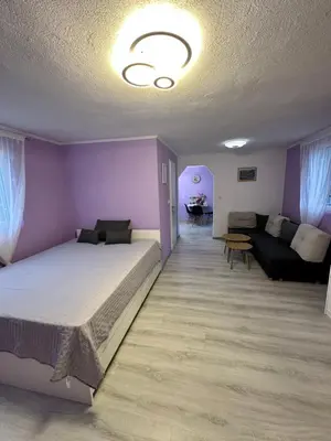 a bedroom with purple walls and a bed and a couch at HH Lakes Tuzla - city center, free parking! in Tuzla