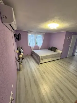 a bedroom with a bed and purple walls at HH Lakes Tuzla - city center, free parking! in Tuzla