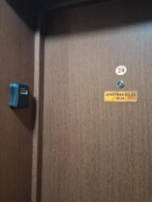 a wooden door with a sign on it at Apartman Atlas in Doboj