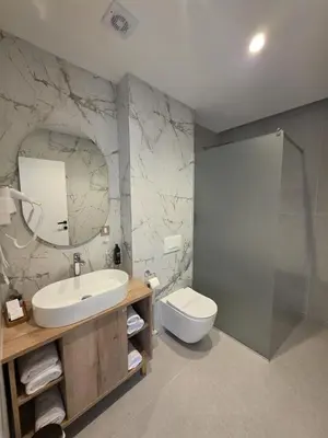 a bathroom with a sink and a toilet and a mirror at Hotel Cat Deluxe in Sanski most