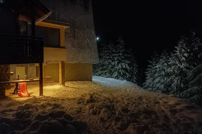 a night time picture of a building in the snow at Apartman 1001 in Vlasic