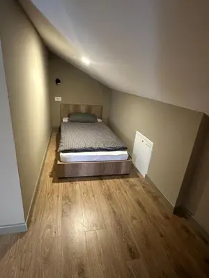 a bed in a small room with a wooden floor at Mountain house Mia Tereza in Kupres