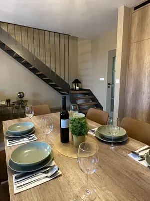 a table with plates and wine glasses on it at Mountain house Mia Tereza in Kupres