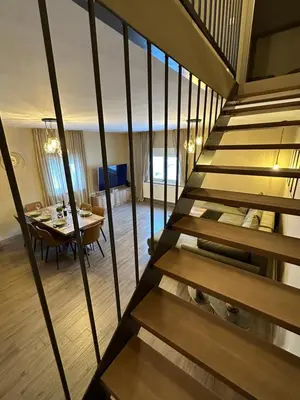 a staircase leading to a dining room with a table at Mountain house Mia Tereza in Kupres