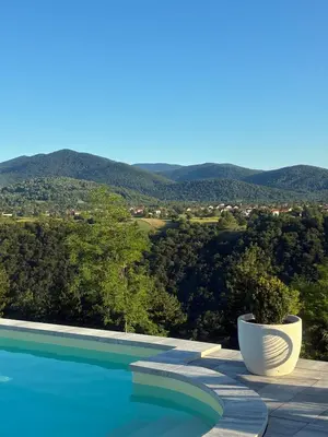 a swimming pool with a view of the mountains at Balun BLKN in Ostrožac