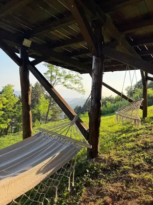 two hammocks hanging from a wooden structure in a field at Balun BLKN in Ostrožac