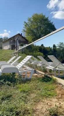 a row of white chairs sitting in the grass at Balun BLKN in Ostrožac
