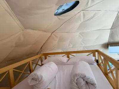 a bed in a tent with a mouse on the ceiling at Balun BLKN in Ostrožac