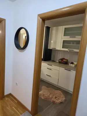 a kitchen with white cabinets and a mirror at Apartman Dora'K in Doboj