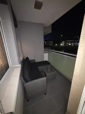 a balcony with a couch and a table at Apartman Dora'K in Doboj