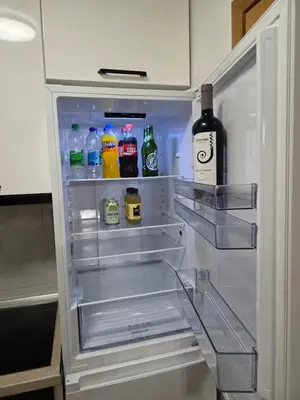 an open refrigerator with drinks and a bottle of wine at Apartman Dora'K in Doboj