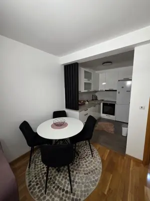 a kitchen and dining room with a white table and chairs at Apartman Dora'K in Doboj