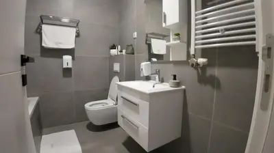 a bathroom with a white toilet and a sink at Apartman za 5 in Banja Luka