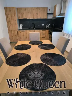 a wooden table with a white onion sign on it at White Quenn Apartments in Sanski most