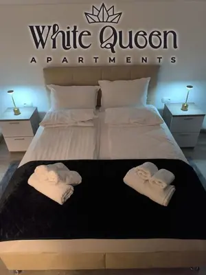 a bedroom with a bed with two towels on it at White Quenn Apartments in Sanski most
