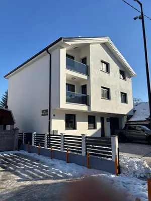 a white apartment building with snow on the ground at White Quenn Apartments in Sanski most