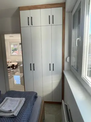 a bedroom with a bed and a white cabinet at Apartment Welcome in Modriča