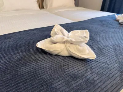 a pair of white shoes sitting on a bed at Hotel Modriča in Modriča