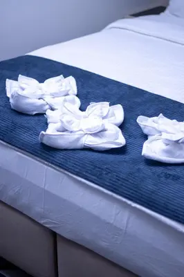 a group of white shoes sitting on a bed at Hotel Modriča in Modriča