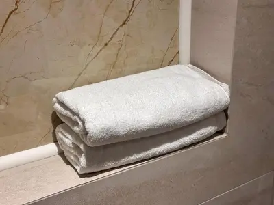 a pile of towels sitting on a shelf in a bathroom at Hotel Modriča in Modriča
