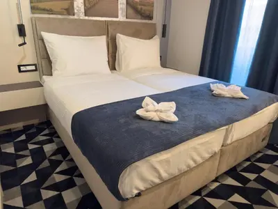 a bedroom with a bed with two white flowers on it at Hotel Modriča in Modriča
