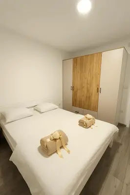 two towels on a white bed in a room at Apartman Prijedor in Prijedor